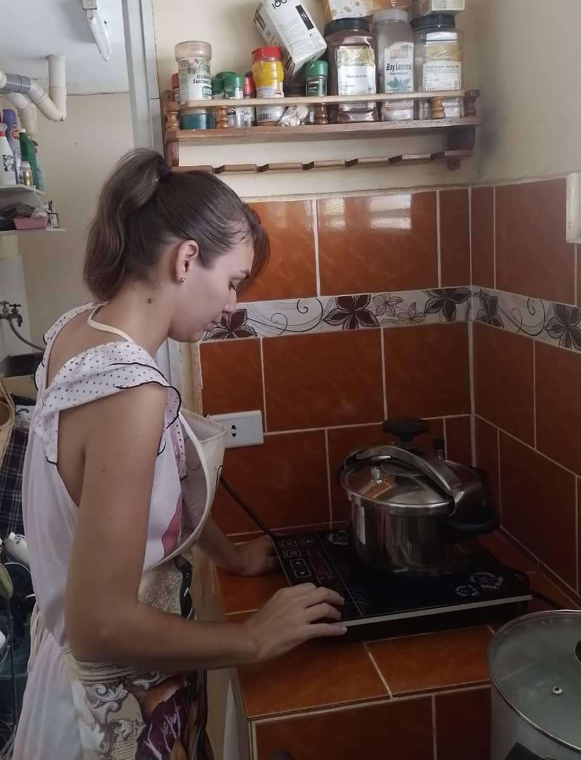Amelia Calzadilla usa una hornilla de inducción para cocinar.