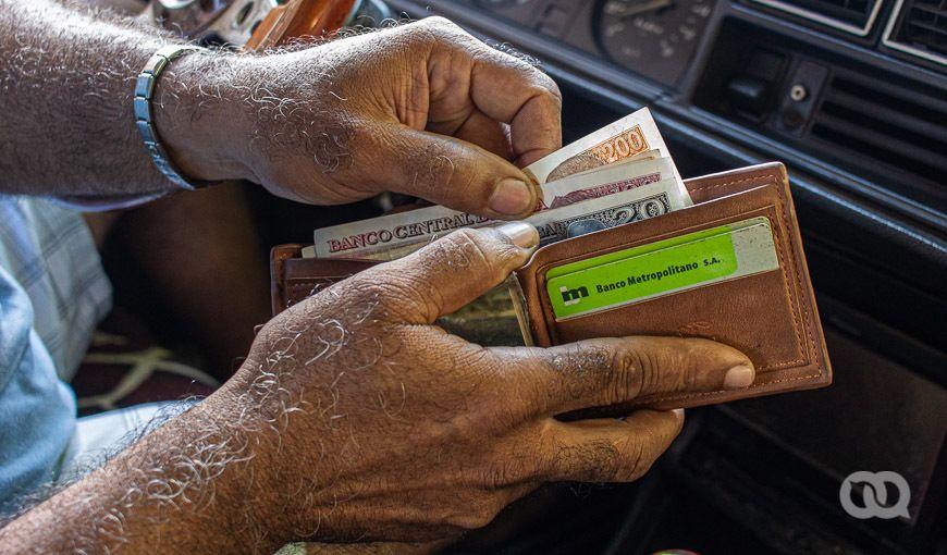Billetes y tarjetas magnéticas en Cuba, manos, billetera, inflación