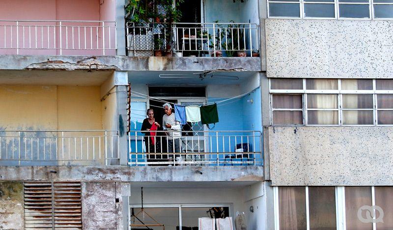 Ancianos tienden jabas vacías en el balcón de su vivienda.