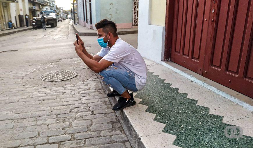 Joven con teléfono en una calle de Cuba. Las redes sociales, a las cuales los cubanos han accedido más en los últimos dos años, fueron y son vía de propagación de un gran número de desinformaciones relacionadas con la COVID-19.