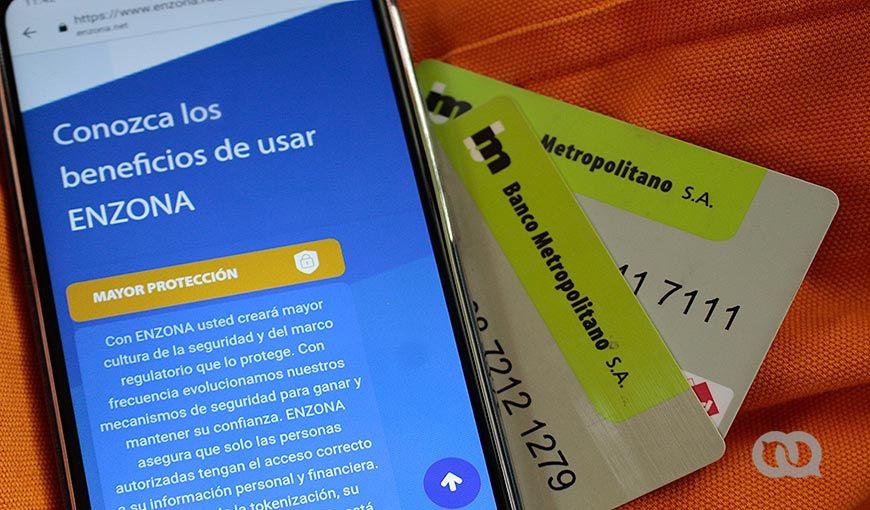 Teléfono celular que muestra la aplicación de EnZona, una pasarela de pago cubana, y dos tarjetas del Banco Metropolitano de La Habana