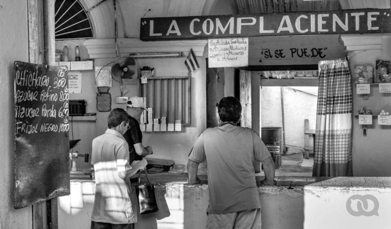 Personas en bodega cubana compra de alimentos.