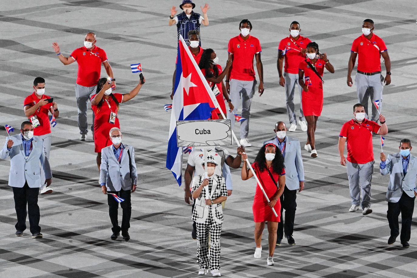 Mijain López y Yaima Pérez, abanderados de Cuba, encabezan la delegación durante la ceremonia de inauguración de los Juegos Olímpicos de Tokio 2020. Foto: Martin Bureau (AFP).
