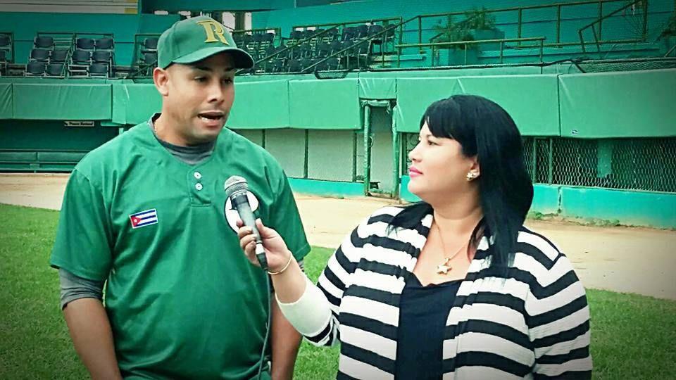 Yuliet Pérez Calaña, entrevistando al tercera base pinero, Michel Enríquez. Foto: Cortesía de la entrevistada.