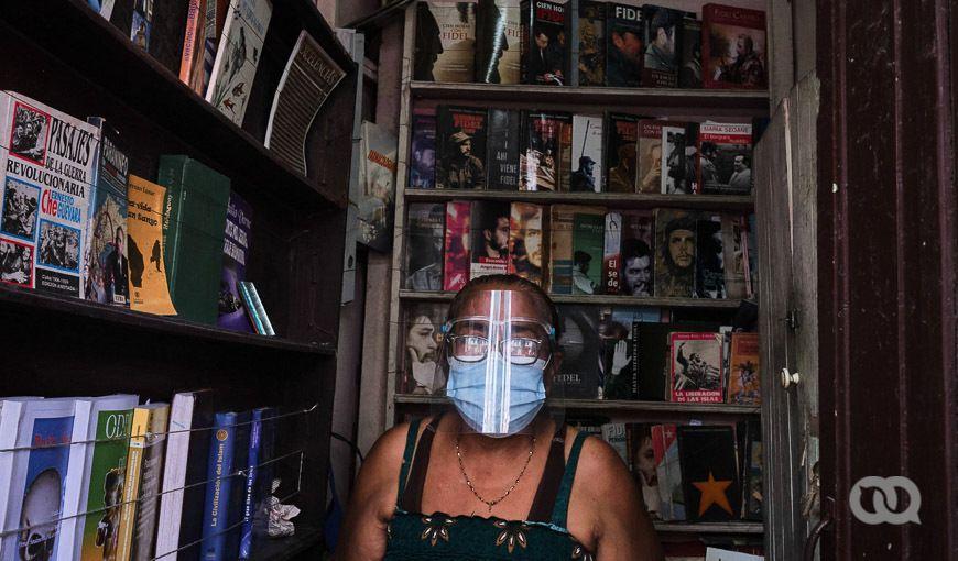 Vendedora de libros en La Habana con medios de protección por la pandemia de coronavirus. Felicia en su local de venta de libros de segunda mano. Foto: Natalia Favre.
