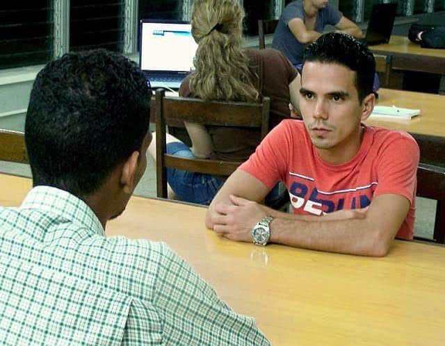 creditos_universitarios-Cuba-economía-educación-joven-sentado-frente-a-otro-dinero.jpg