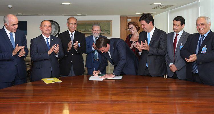 Momento en que el presidente Jair Bolsonaro sentencia la ley del nuevo programa médico. Foto: Marcos Corrêa / PR