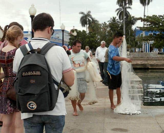 turistas-contemplan-pescadores-en-Cienfuegos-Cuba-turismo-economía-empleo.jpg